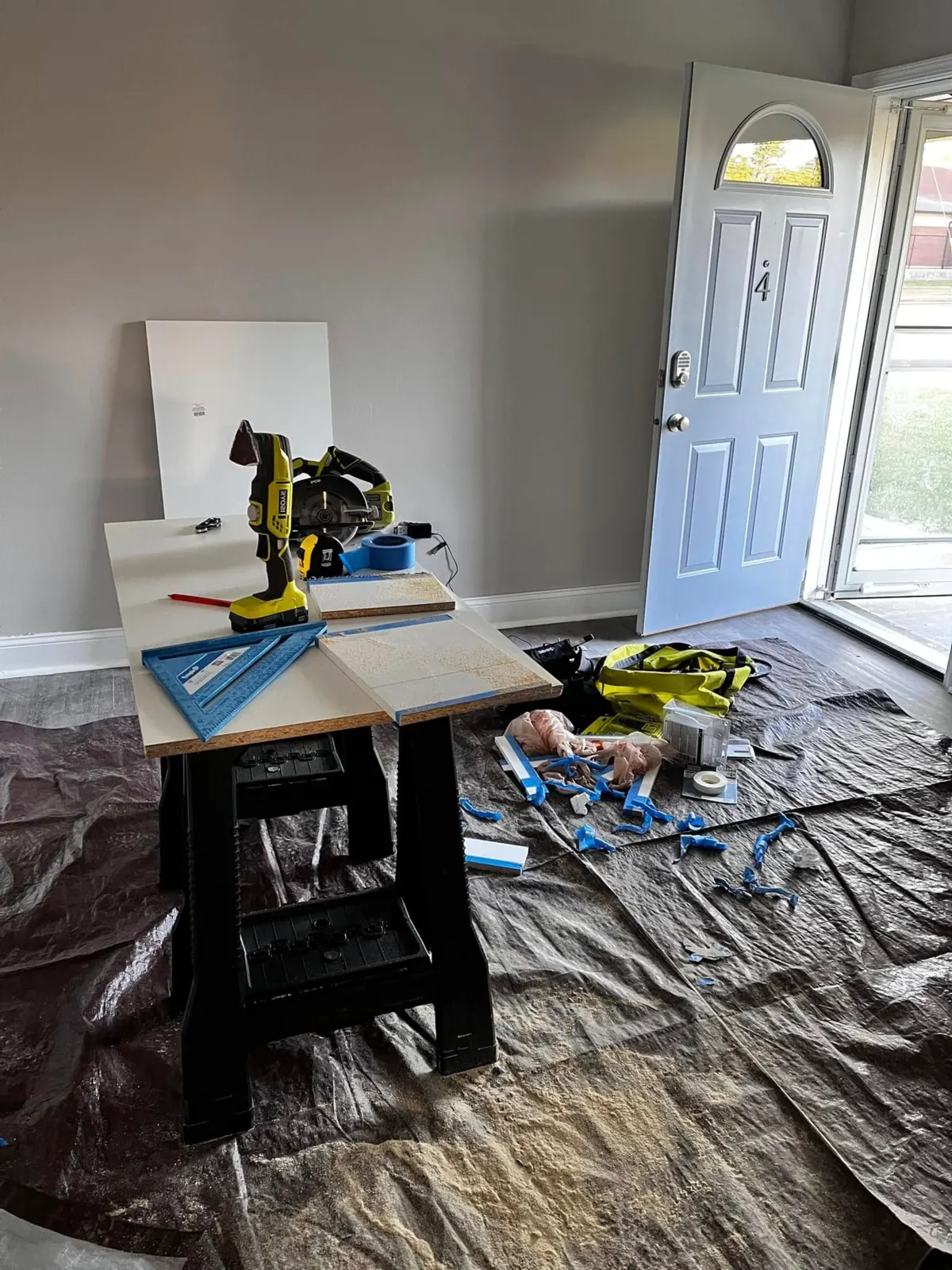 Tools and cabinet materials arranged over protective floor coverings during installation